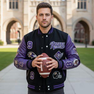 Man wearing a black and purple letterman jacket with 'Ravens' branding, holding a football in front of an architectural background.
