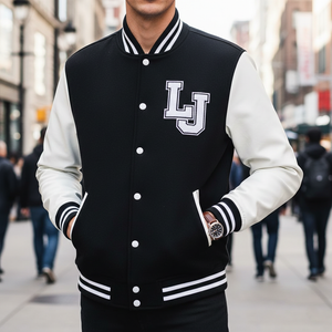 Person wearing a black and white varsity jacket with 'LJ' logo on a city street.