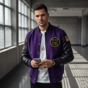 Man wearing a purple varsity jacket with a logo, standing in a modern indoor setting.