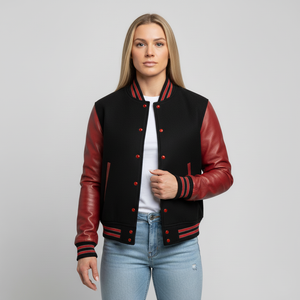 Girl wearing a black and red varsity jacket on a gray background