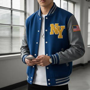Person wearing a blue and gray varsity jacket with 'NY' and an American flag patch, holding a phone.