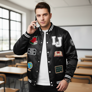 Man wearing a black letterman jacket with patches in a classroom setting