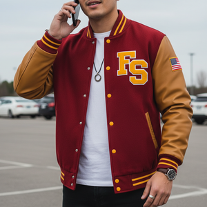 Person wearing a red and gold varsity jacket with 'FS' and an American flag patch, talking on a phone in a parking lot.