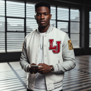 Man wearing a gray letterman jacket with 'LJ' logo, holding a phone indoors.
