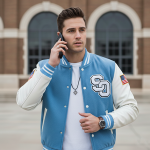 Man wearing a blue and white varsity jacket with an 'SO' logo, talking on a phone outdoors.