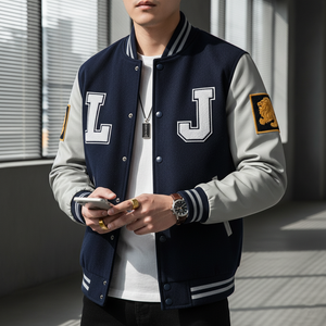 Person wearing a navy and gray varsity jacket with 'L' and 'J' letters, holding a phone.