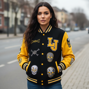 Woman wearing a black and yellow varsity jacket with skull designs on a street.