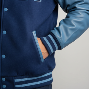Navy blue varsity jacket with light blue accents on a gray background