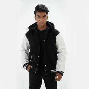 Front view of black and white hooded letterman jacket featuring wool body white leather sleeves and snap-button fastening