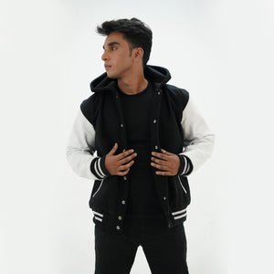 Side angle of black and white hooded letterman jacket highlighting genuine cowhide white leather sleeves and quilted lining