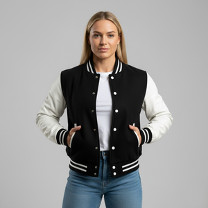 Woman wearing a black and white varsity jacket on a gray background