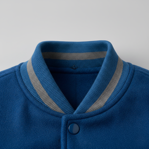 Close-up of a blue cardigan with a gray collar on a light gray background