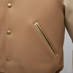 Close-up of a beige jacket with gold buttons and a pocket detail on a light gray background