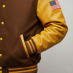 Brown and yellow varsity jacket with American flag patch on sleeve against a gray background