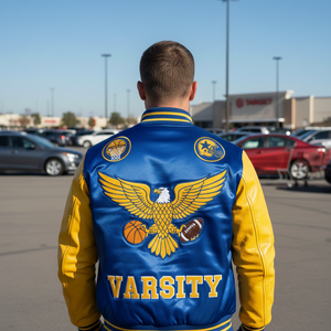 Person wearing a blue and yellow varsity jacket with an eagle design in a parking lot.