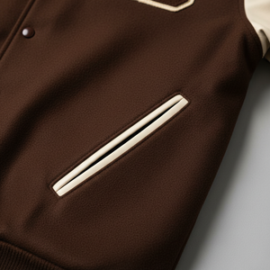 Brown jacket with white zipper and trim on a light gray background