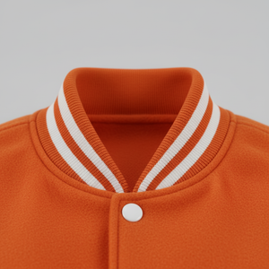 Close-up of an orange jacket with a white collar and button on a gray background