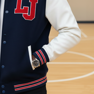 Person wearing a navy blue letterman jacket with red and white accents, standing on a basketball court.