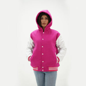Three-quarter angle of girls pink hooded letterman jacket highlighting snap buttons, hood design, side pockets, and pink-white color combination