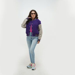 Three-quarter view of girls purple crop letterman jacket highlighting snap button closure, cropped hem, and purple-gray color contrast