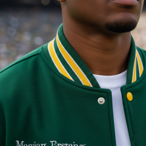 Green varsity jacket with yellow and white striped collar worn by a person.