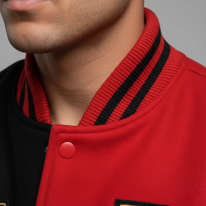 Close-up of a person wearing a red and black varsity jacket with a button.