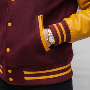 Side view of K letterman jacket showing button front closure and yellow ribbed waist hem