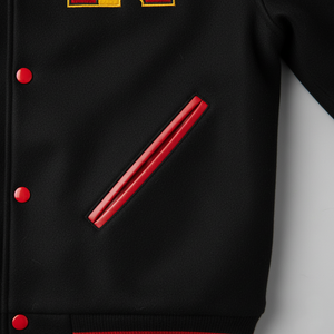 Black letterman jacket with red buttons and trim on a light gray background