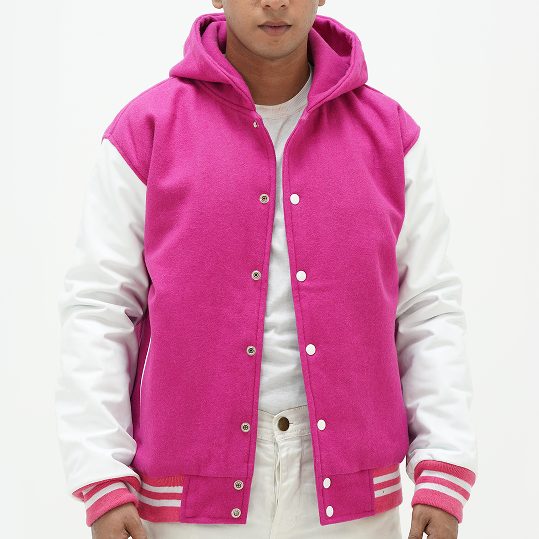 A man wearing a pink and white varsity jacket with a hood, featuring leather sleeves and a front with snap buttons. The jacket has pink ribbing and white stripes, and it is presented against a white background.
