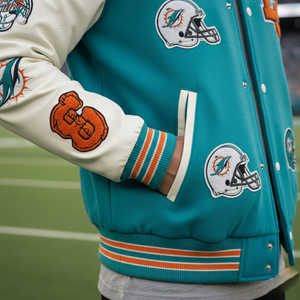 Teal letterman jacket with sports team logos on a football field background