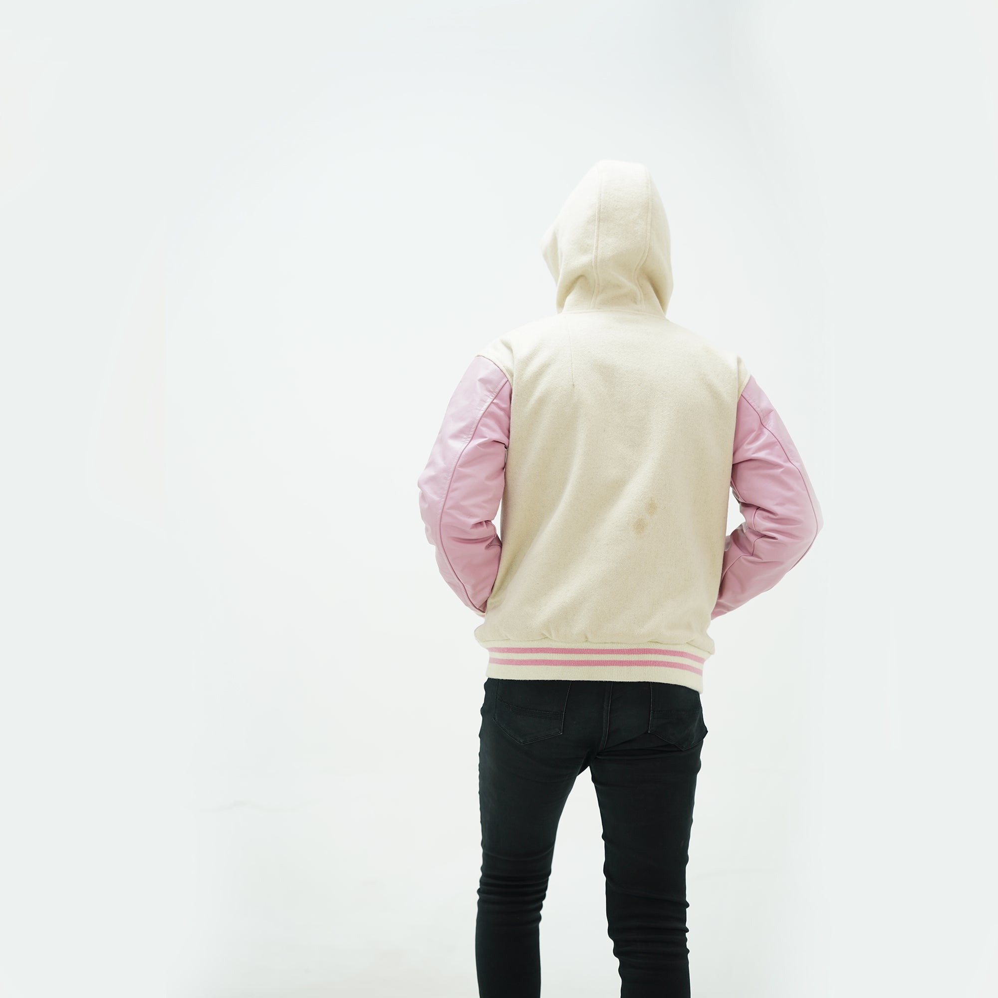 Back view of off white and pink hooded varsity jacket combining classic varsity tradition with modern design