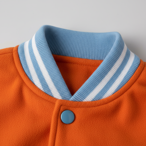 Close-up of an orange jacket with a blue collar and button on a gray background