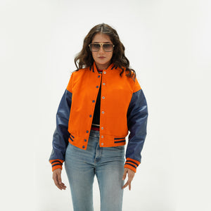 Close-up detail of orange and java plum crop jacket featuring orange wool and java plum leather sleeve junction with ribbed collar trim