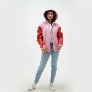 Three-quarter view of pink wool hooded letterman jacket with contrasting red leather sleeves and adjustable hood