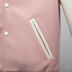Close-up of a pink jacket with white buttons and trim on a light gray background