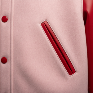 Close-up of a pink varsity jacket with red buttons and pocket.