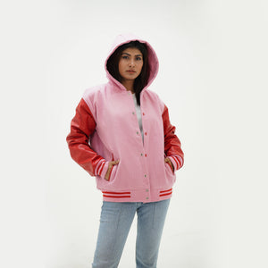 Side profile of pink hooded varsity jacket showing white leather raglan sleeves and red striped ribbed cuffs
