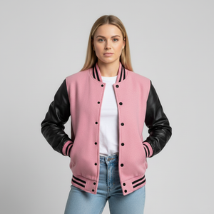 A girl wearing a pink varsity jacket with black sleeves on a gray background