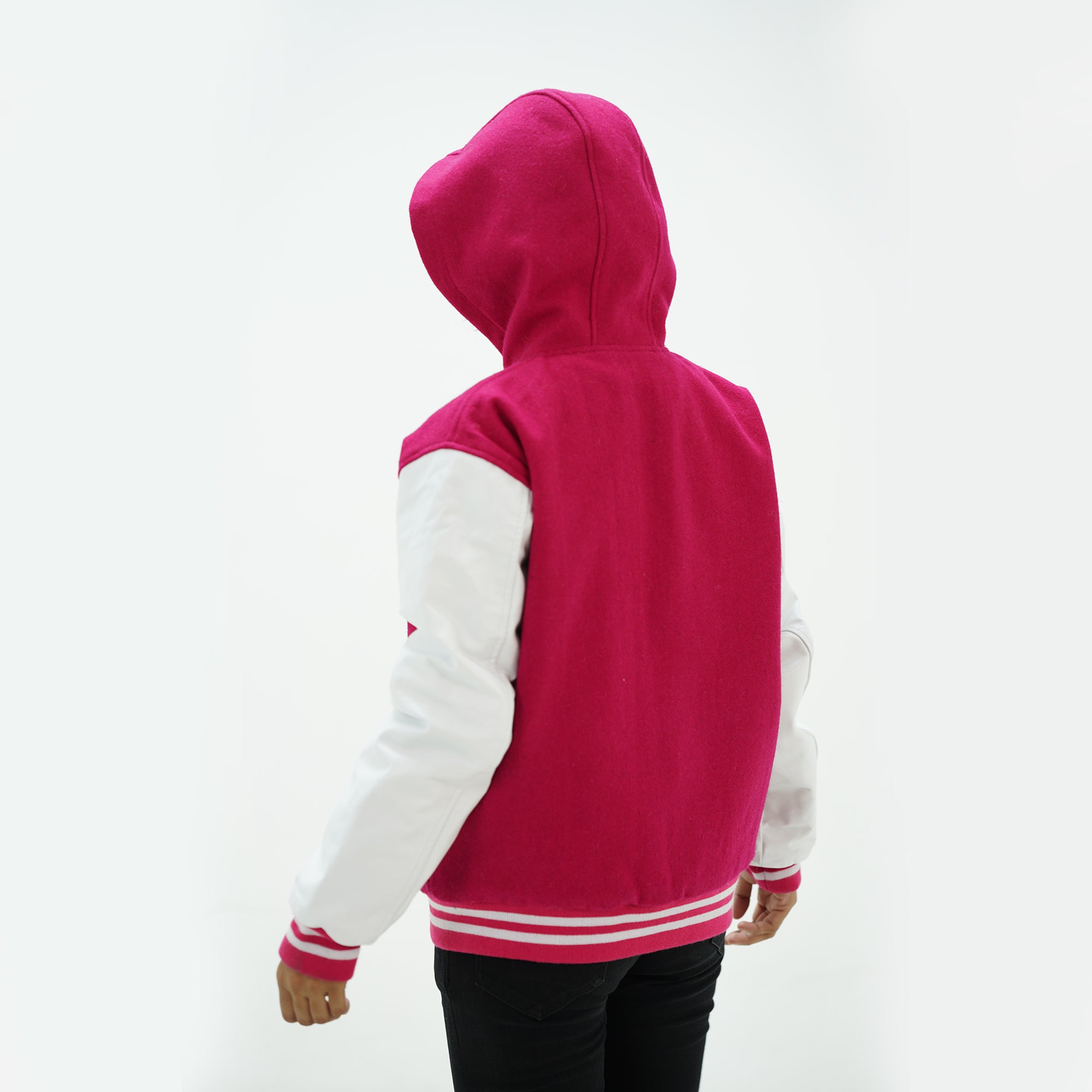 Back view of girls pink and white letterman jacket with hood displaying wool body and white leather sleeves with ribbed waistband