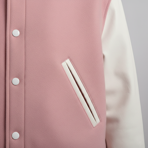 Close-up of a pink varsity jacket with white sleeves and buttons.