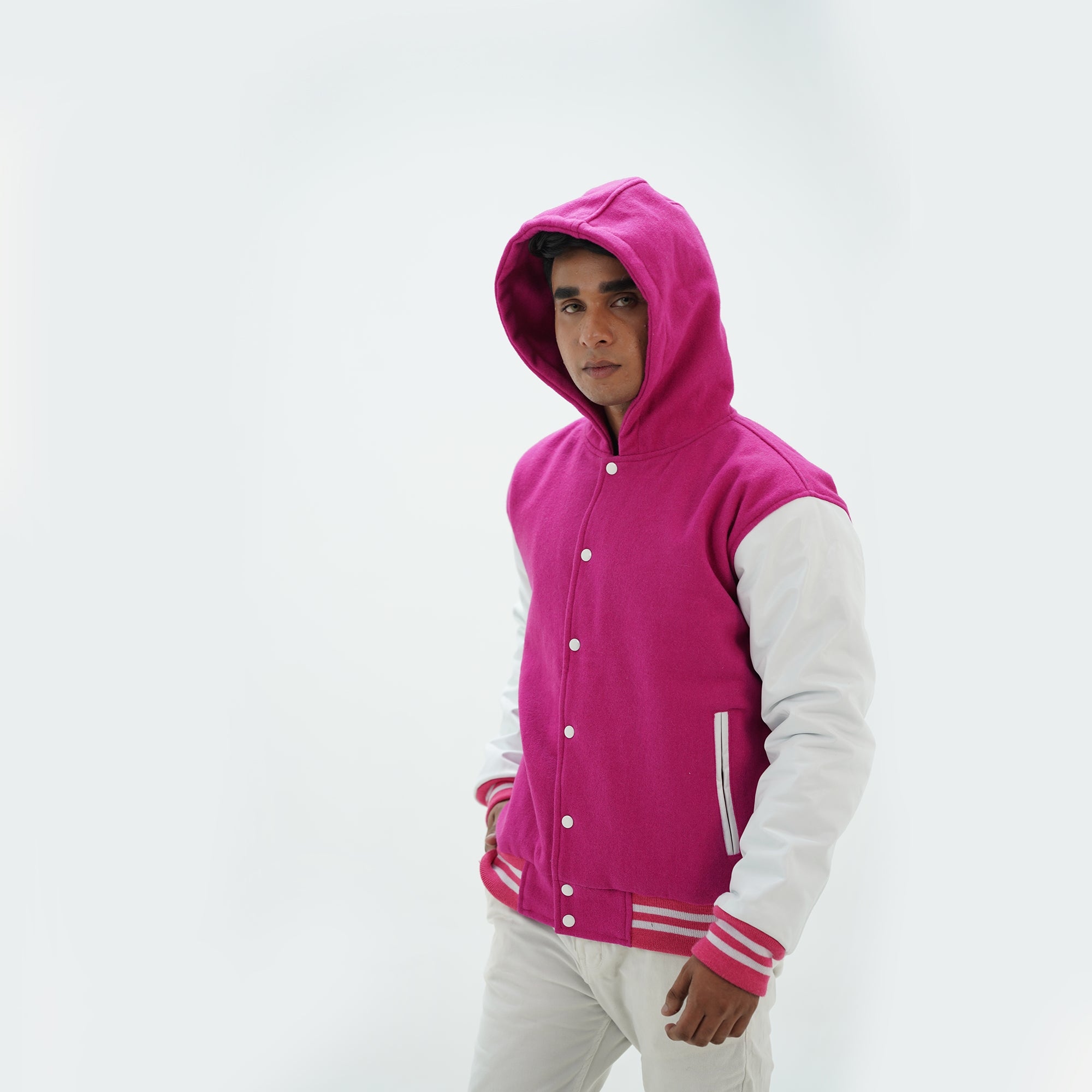 Side angle of men's pink and white varsity jacket with hood highlighting leather sleeves and wool body