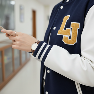 Person wearing a navy and white letterman jacket with 'LJ' on it, using a phone.