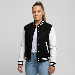 Woman wearing a black and white varsity jacket on a gray background