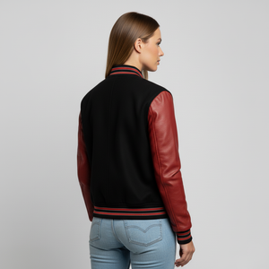 Woman wearing a black and red varsity jacket on a gray background