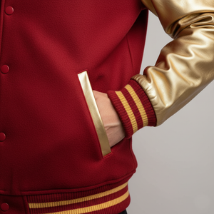 Red and gold varsity jacket with a gold sleeve and pocket on a gray background