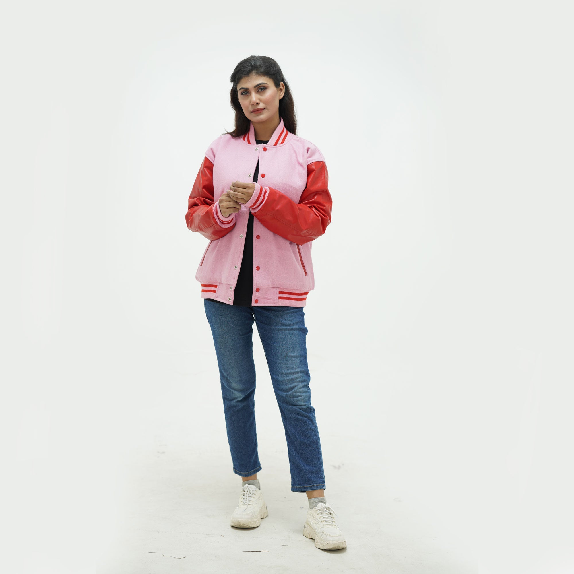 zoomed-out view of women's red and pink letterman jacket displaying ribbed waistband, pink leather sleeves, and premium wool construction