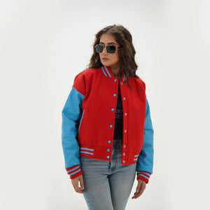 Close-up detail of red and sky blue varsity jacket featuring red wool and sky blue leather sleeve junction with ribbed collar trim