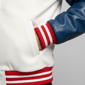 Close-up of a person wearing a white jacket with red and white striped sleeves on a light gray background