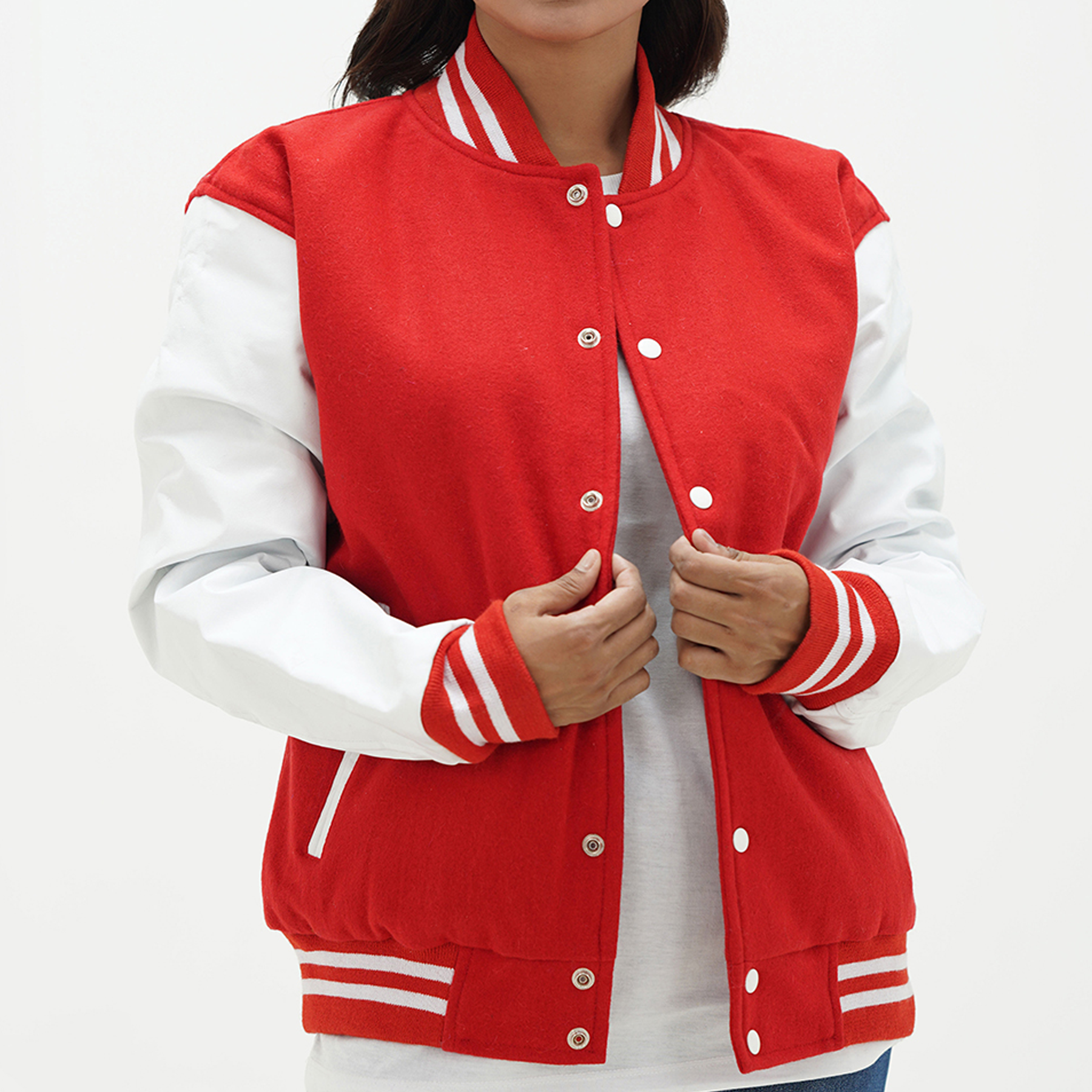 A woman wearing a red and white letterman jacket with leather arms and a wool body, featuring a classic ribbed collar, ribbed cuffs and hem, and coated snap-button fastening.