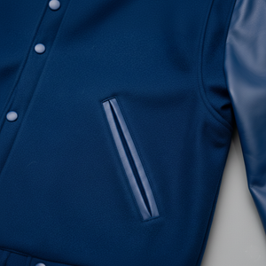 Close-up of a blue jacket with a pocket and button details on a light gray background